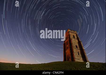 Eine Stunde lang Exposition von Glastonbury Tor, Somerset, zeigt Sternspuren Verwirbelung in den Himmel über St. Michael Turm. Stockfoto