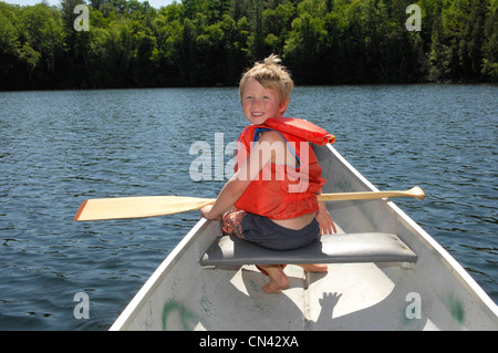 Young Boy in einem Kanu mit einer Rettungsweste auf Lac des Neiges, Quebec Stockfoto