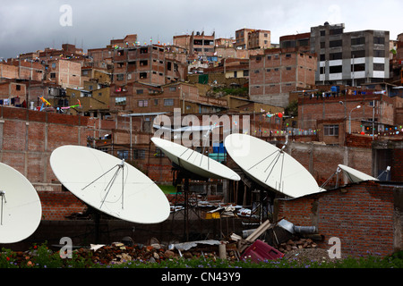 Satellitenfernsehen, Geschirr und Backsteinhäuser am Hang in den Vororten von Puno, Peru Stockfoto