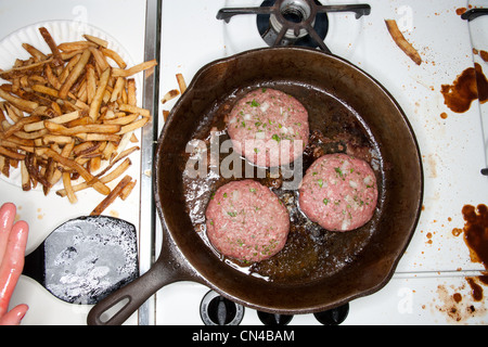 In einer Pfanne Kochen Burger Stockfoto