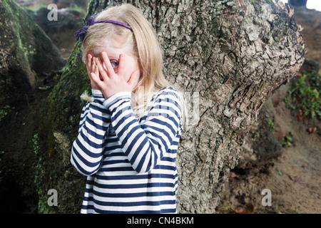 Mädchen mit bedeckten Augen gucken Stockfoto