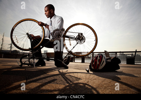 Junger Geschäftsmann reparierte Fahrrad Stockfoto