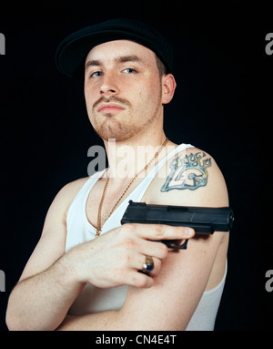 Junger Mann halten Pistole, portrait Stockfoto