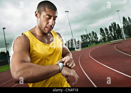 Sprinter Blick auf Uhr auf Rennstrecke Stockfoto