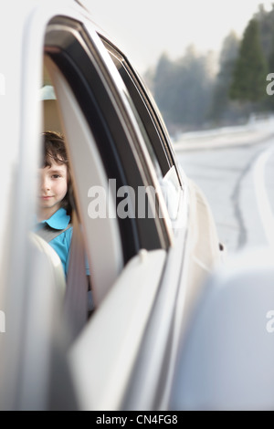 Junge sitzt auf dem Rücksitz eines Autos Stockfoto