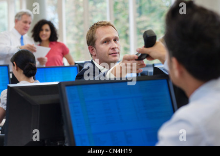 Büroangestellte, die vorbei Telefon an Kollegen im Büro Stockfoto