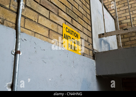 Warnzeichen für "Anti-Aufstieg Paint' Stiegenhaus in einem Block des sozialen Wohnungsbaus Maisonetten am Waschbecken Estate in Basildon, Essex. Stockfoto