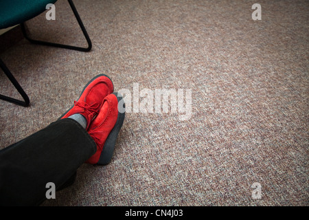 Rote Schuhe im Wartezimmer Stockfoto