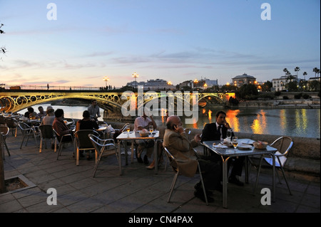 Spanien, Andalusien, Sevilla, Fluss Guadalquivir Banken mit der Puente de Isabel II besser bekannt als Puente de Triana-Brücke Stockfoto