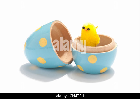 Ein Oster-Küken-Deko in einem hölzernen Ei Stockfoto
