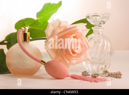 Zwei kleine Flaschen und weiche rosa Rose mit grünen Blättern Stockfoto