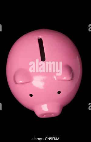 Draufsicht auf ein rosa Sparschwein auf schwarzem Hintergrund isoliert Stockfoto