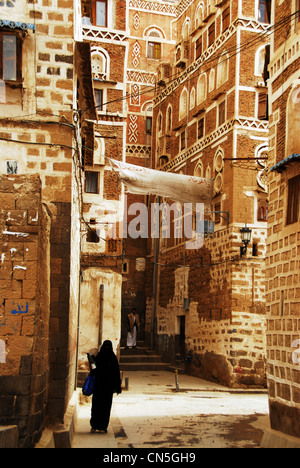 Jemen, Sanaa, Altstadt als Weltkulturerbe der UNESCO, Frau mit Burka zu Fuß auf einer Fahrspur aufgeführt Stockfoto