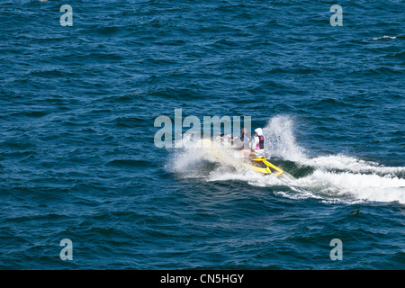 Junge, einen Jetski fahren und haben einen Passagier Stockfoto