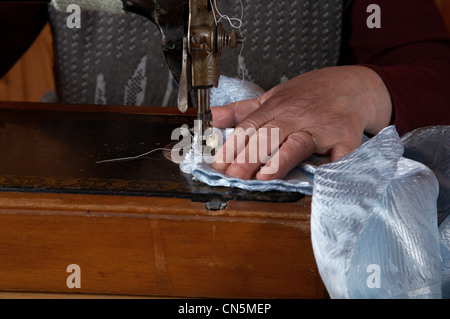 Die alte Frau näht an der Nähmaschine Stockfoto