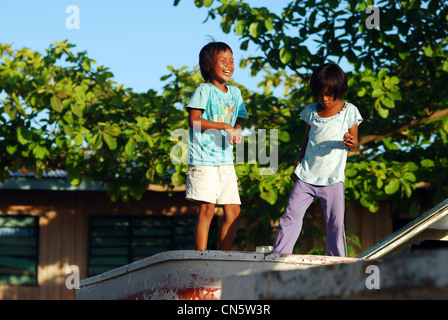 Malaysia, Borneo, Sabah State, Semporna, Mabul, Seezigeuner (Dayak Lau) Kinderlachen auf Boot am Ufer Stockfoto