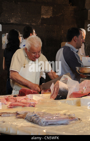 Fischhändler beim Schneiden von Schwertfisch, Catania, Italien Stockfoto