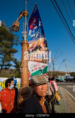 Südkorea, Gyeongsan Noord, Cheongdo, koreanische Mann vor einem Plakat Werbung für einen Stierkampf-festival Stockfoto