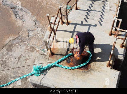 Ein Hafen-Arbeiter sichert die Festmacher von Gozo, Malta Fähre am Cirkewwa Malta Terminal. Stockfoto