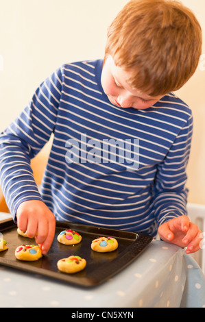 Ein 8 Jahre alter Junge, so dass Cookies zu Hause in England, Großbritannien, Vereinigtes Königreich Stockfoto