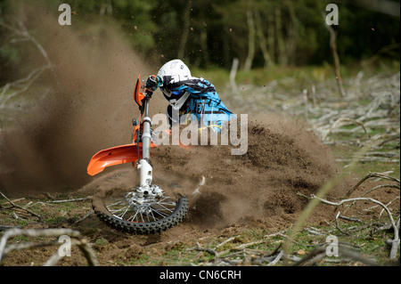 Racer Motocrossfahrer Ecke werfen viel Schlafplatz und Schmutz in der Luft hinter dem Motorrad herumfahren Stockfoto