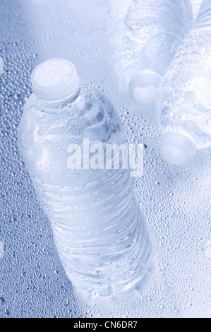 Hohen Winkel gedreht mit geringen Schärfentiefe drei Wasserflaschen auf nassem Untergrund. Stockfoto