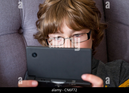 Ein Junge spielt auf einem Handheld Nintendo DSi-Spiele-Konsole Stockfoto