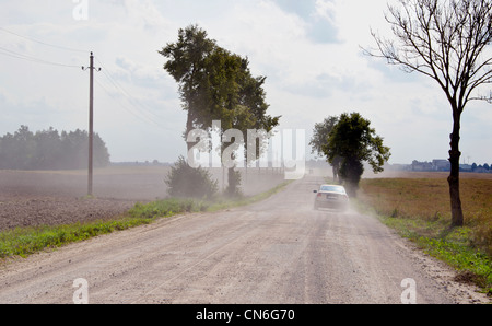 Staubige ländlichen Schotterstraße zwischen Äckern und die Maschine in Gang. Stockfoto