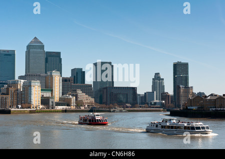 Touristische boote vorbei an der Skyline von Canary Wharf, London, England. Stockfoto