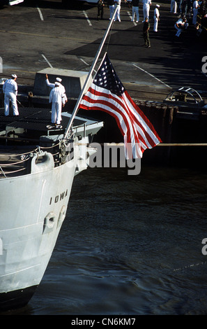 Die amerikanische Flagge fliegt am Halbmast vom Heck des Schlachtschiffs USS Iowa (BB-61), als das Schiff nach einer Ausreise, bei der 47 Besatzungsmitglieder getötet wurden, in den Heimathafen zurückkehrt. Die Explosion ereignete sich im 16-Zoll-Geschützturm Nr. 2, als die Iowa am 19. April Routineübungen rund 300 Meilen nordöstlich von Puerto Rico durchführte. Stockfoto