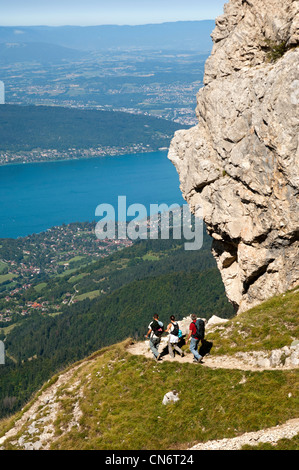 Aufsteigende Wanderer auf einem schmalen Trail auf den Tournette Zuflucht im Massiv des Bornes über dem See von Annecy, Frankreich Stockfoto