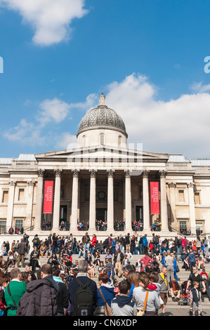 LONDON, UK - APRIL 02: Fassade von der National Gallery am Trafalgar Square, mit Öffentlichkeit, die die Sonne genießen. Stockfoto