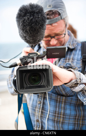 Ein Mann macht eine Video für die Ausstrahlung im Fernsehen mit einem Sony HD Kamera, UK Stockfoto