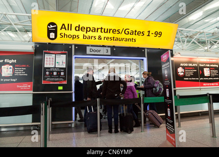 Fluggäste, die Sicherheitskontrolle auf Abfahrten, Stansted Flughafen Essex UK Stockfoto