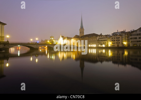 Blick auf Zürich und Altstadt reflektiert in der Limmat in der Nacht. Stockfoto