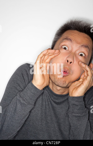 Chinesische asiatische Mann tragen Langarm-Shirt in Richtung Kamera weht. Stockfoto