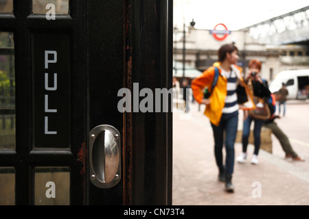 Touristen posieren für Fotos in der Nähe eines schwarzen Londoner Telefonzelle. Stockfoto