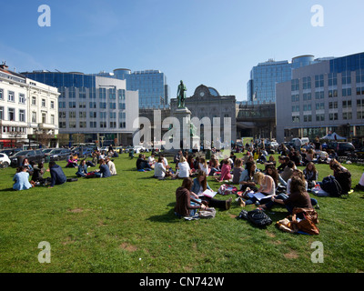 Viele Menschen genießen die Sonne während ihrer Mittagspause brechen auf dem Rasen des Place du Luxembourg in Brüssel, Belgien Stockfoto