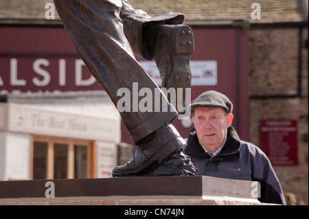 1 mann an der Bronzestatue von cricketer Fred (Freddie) Trueman (Füße & Beine von schnellen Bower in Aktion) - Skipton, North Yorkshire, England, UK. Stockfoto