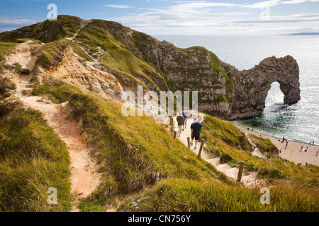 Blick auf Durdle Door auf der Jurassic Coast Küste von Dorset, England, Großbritannien - mit Touristen zu Fuß in Richtung Strand im Sommer Stockfoto