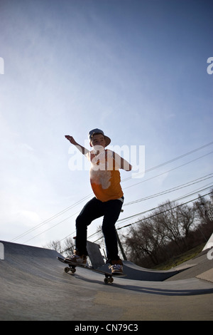 Porträt eines jungen Skateboarder Skaten über eine Rampe an der Skate-Park. Stockfoto