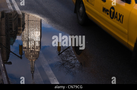 Gelbes Taxi fährt durch eine Reflexion auf das Empire State Building 5th Avenue in New York, NY, USA, 1. Januar 2010. (Adrien Veczan) Stockfoto