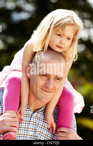 Mädchen setzte sich auf den Schultern der Väter Stockfoto