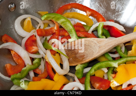 Nahaufnahme der geschnittenen Paprika und Zwiebeln unter Rühren in einem Edelstahl-Wok-Pfanne gebraten werden. Stockfoto