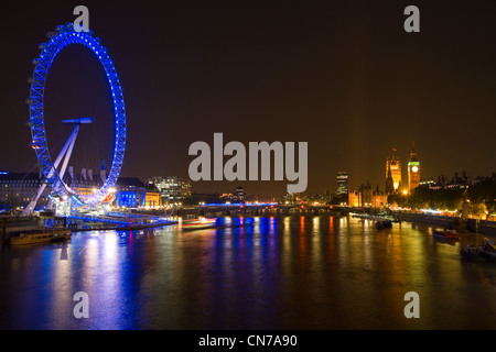 Nacht in London. Lichter aus Westminster und das London Eye reflektieren auf der Themse Stockfoto