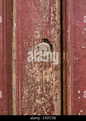 Moderne Schlüsselloch auf einer alten verfallenden Holztür Stockfoto