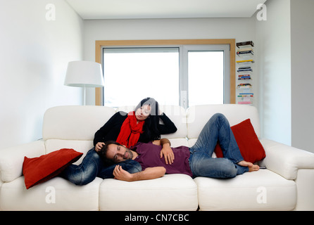 Junges Paar zu Hause im Wohnzimmer sitzt auf einem weißen sofa Stockfoto