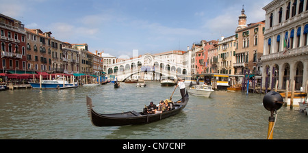 Venezianische Gondel Ruderboot mit Touristen auf den Canal Grande, Venedig. Rialto-Brücke im Hintergrund Stockfoto