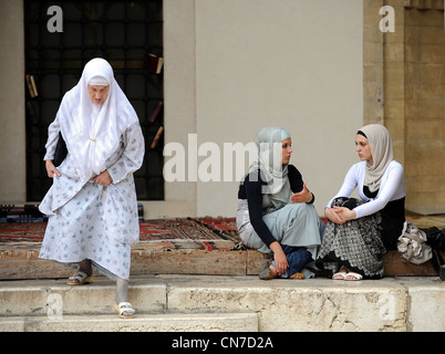 Bosnische muslimische Frauen sitzt vor Gazi Husrev Bey Moschee in Sarajevo Stockfoto