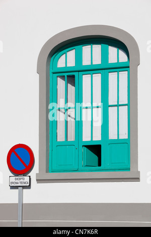 Weißes Gebäude mit türkisfarbenen Fensterrahmen und helle Zeichen in Lanzarote, Kanarische Inseln, Spanien. Stockfoto